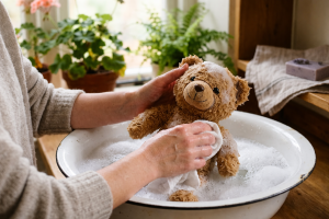 Giặt tay gấu bông với bọt xà phòng.